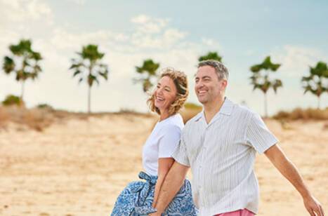 A couple walking along a beach in the Caribbean