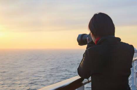 A woman using a camera to take a photo of the horizon
