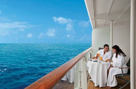 A couple sitting on the veranda of a cruise ship