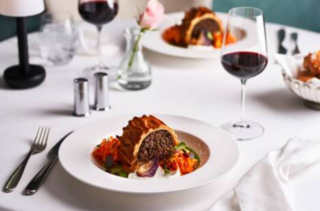 A closeup image of a meal and glass of wine in P&O Cruises' Epicurean restaurant