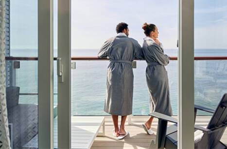 A couple standing on the balcony of a cruise ship
