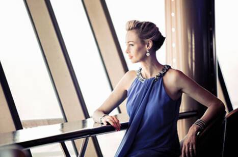 A woman sitting at a bar in formal dress