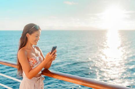 Person holding a phone while looking out at sea