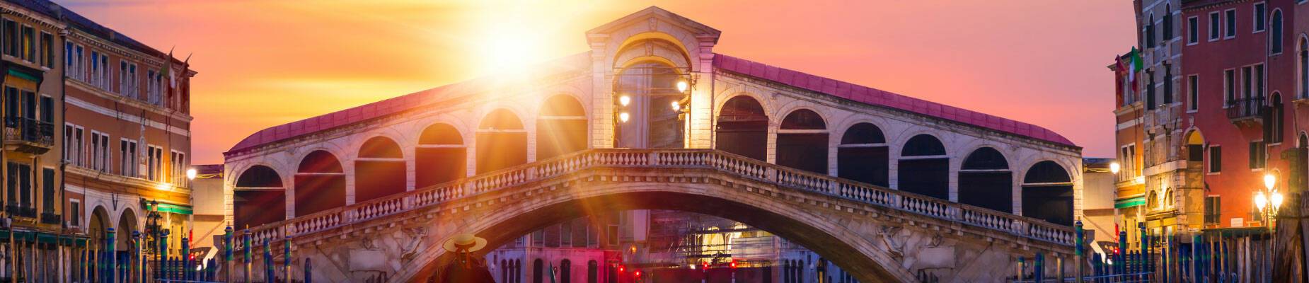 Person on a gondola in front of the Rialto Bridge