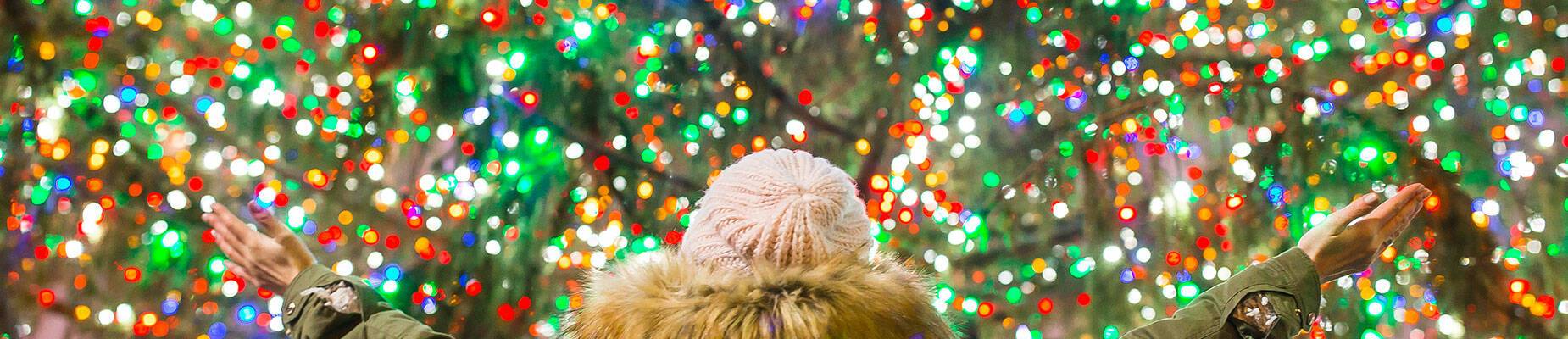 A person standing in front of a Christmas tree