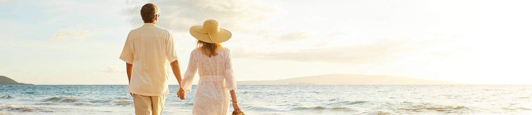 A couple walking hand in hand along a beach
