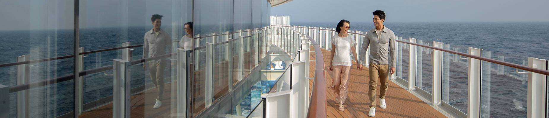 A couple walking along the Promenade Deck on P&O Cruises ship Iona