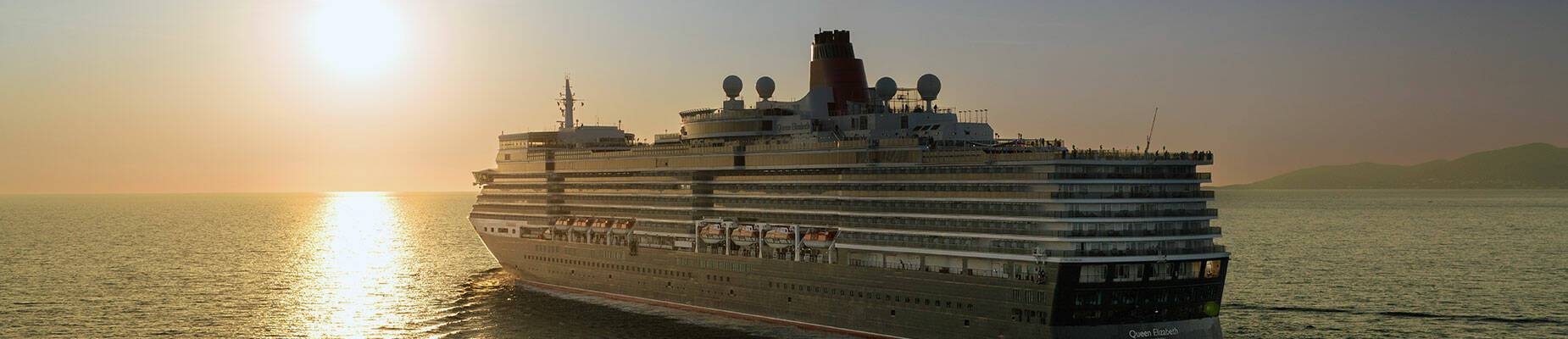 Queen Elizabeth cruise ship sailing towards the sunset