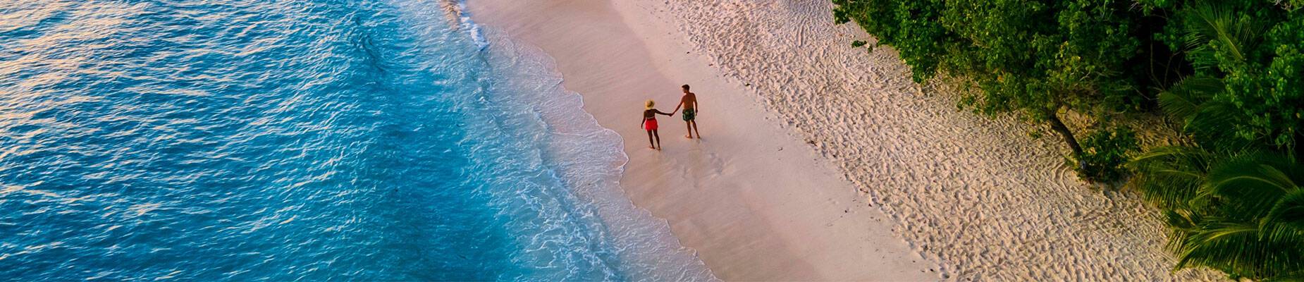 Couple holding hands on an idyllic beach