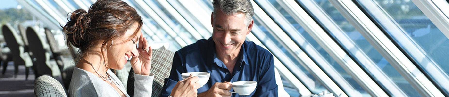 Couple enjoying tea with a view on an Oceania Cruises voyage