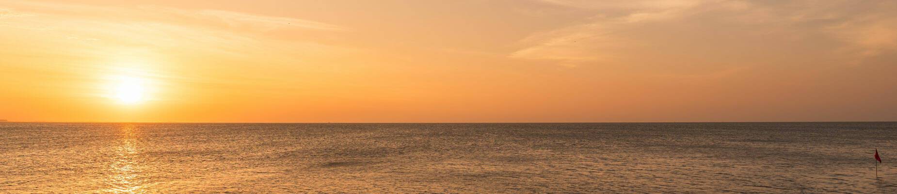 Panoramic image of the sun setting over the horizon