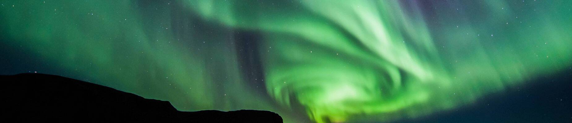 The northern lights in the night sky above water