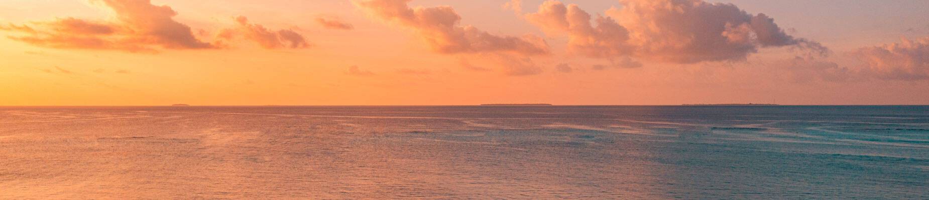 A panoramic image of the sun setting over the horizon