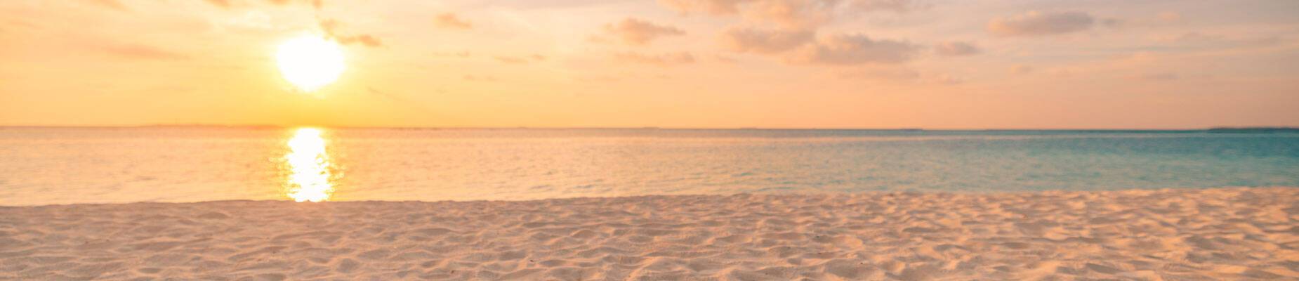 A panoramic image of a beach at sunset