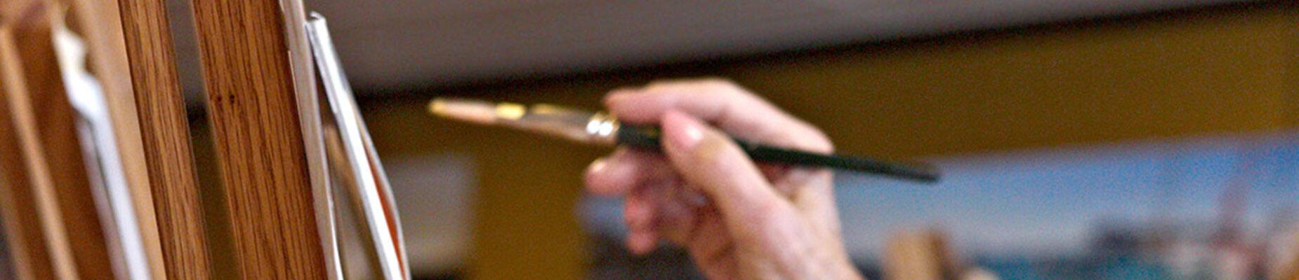 A person painting on an easel