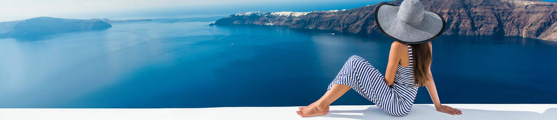 Girl sitting on a wall looking out at sea