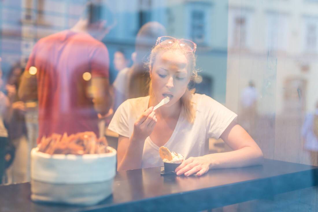 Woman eating gelato in a shop