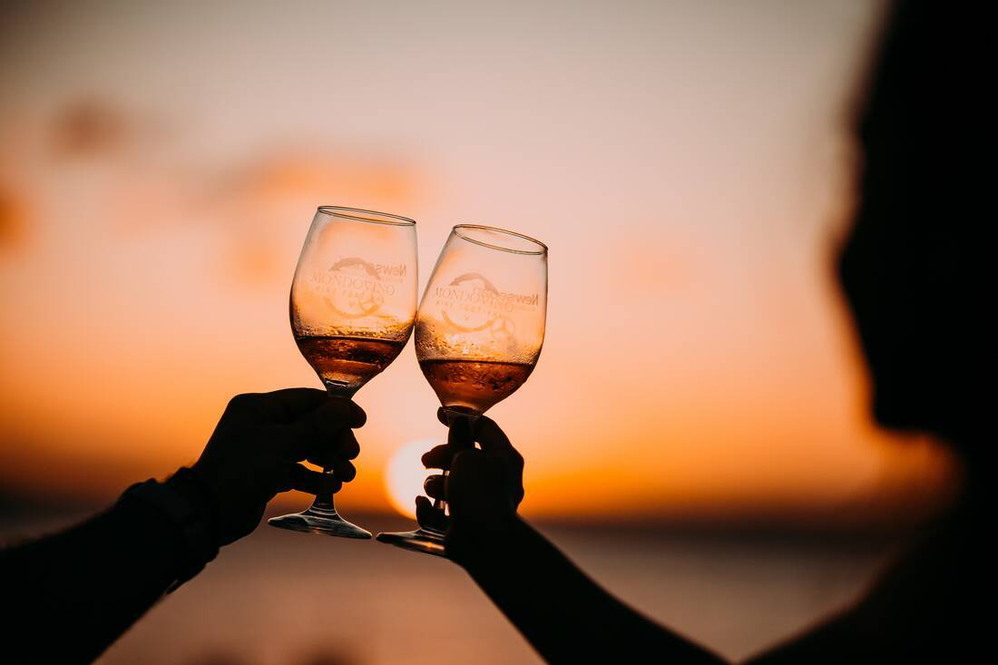 Couple drinking together at sunset