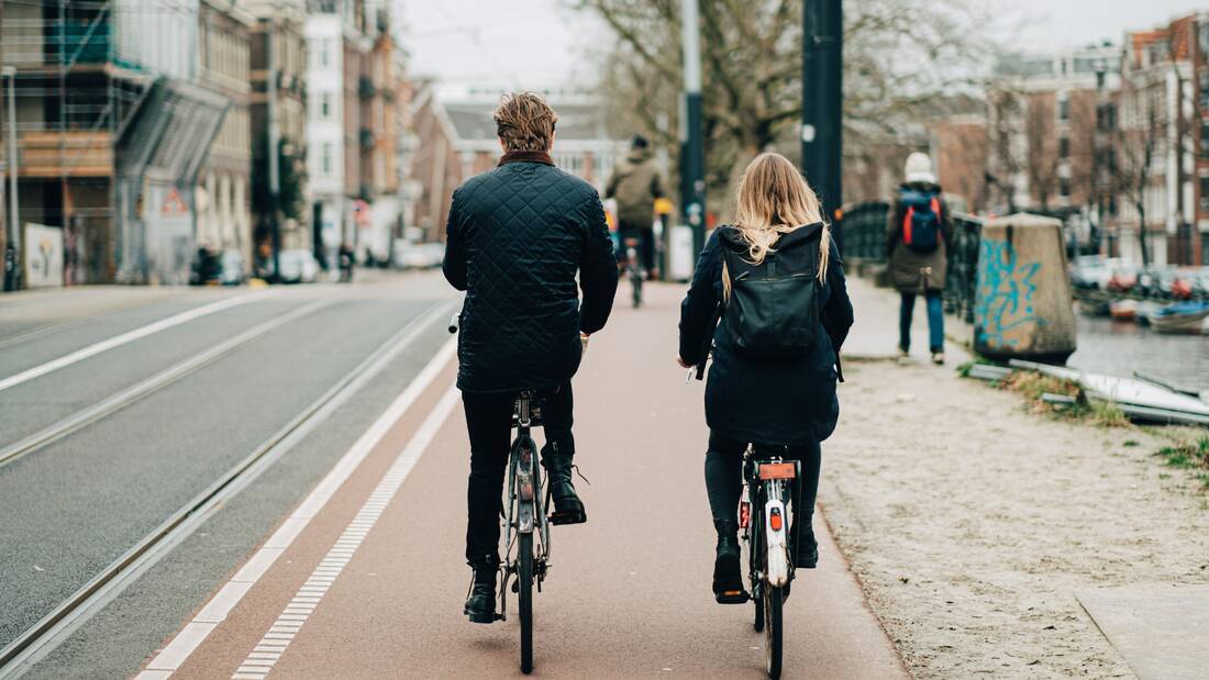Man and woman exploring Amsterdam by bicycle